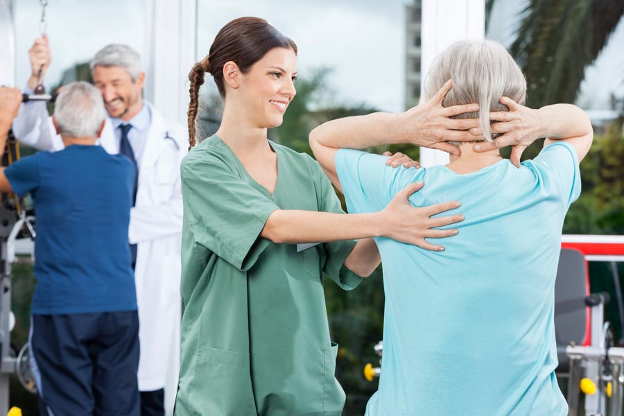nurse helping elderly patient exercise