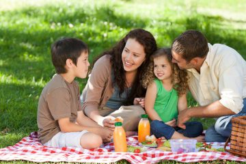 family of mom, dad, son and daughter having a picnic